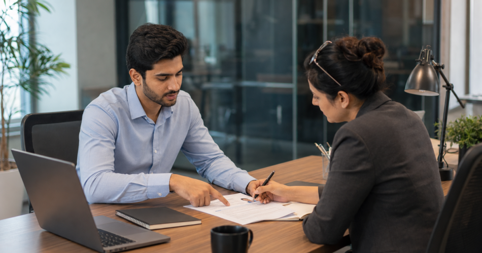 Pakistani hiring manager reviewing a graduate's CV during a first job Pakistan interview